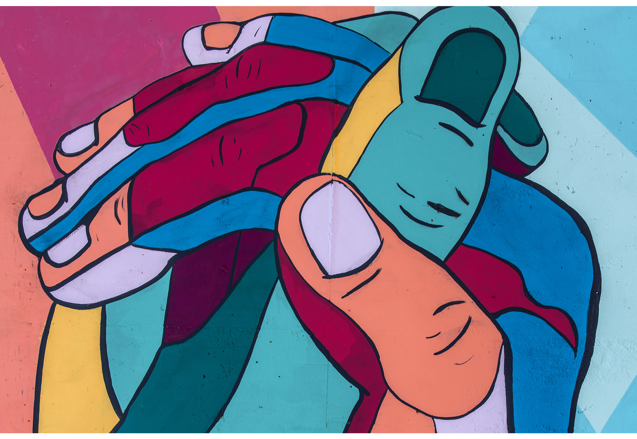 Interlaced fingers of multi-colored hands in a mural.